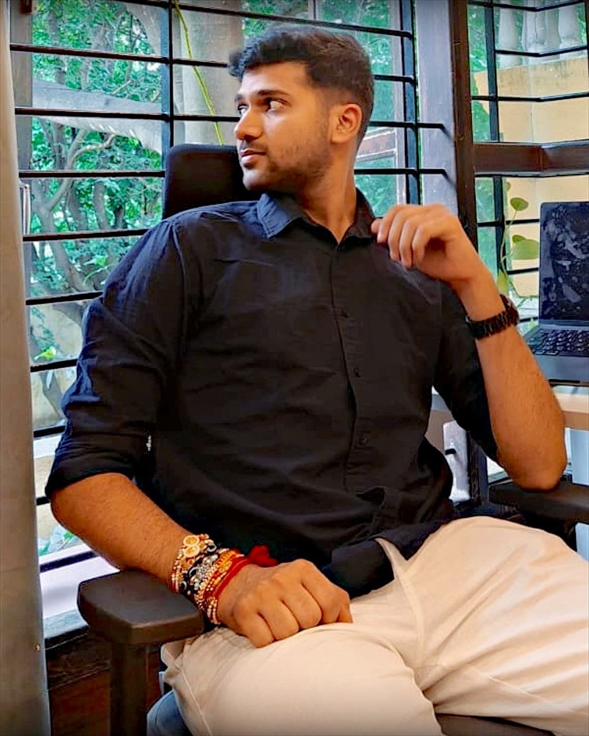 Abhinav Verma in a black shirt, seated at his desk by a window
